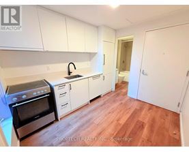 A kitchen with white cabinets and a black stove top oven.