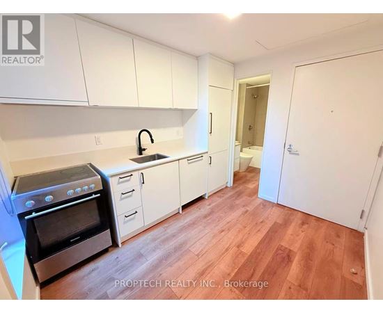 A kitchen with white cabinets and a black stove top oven.