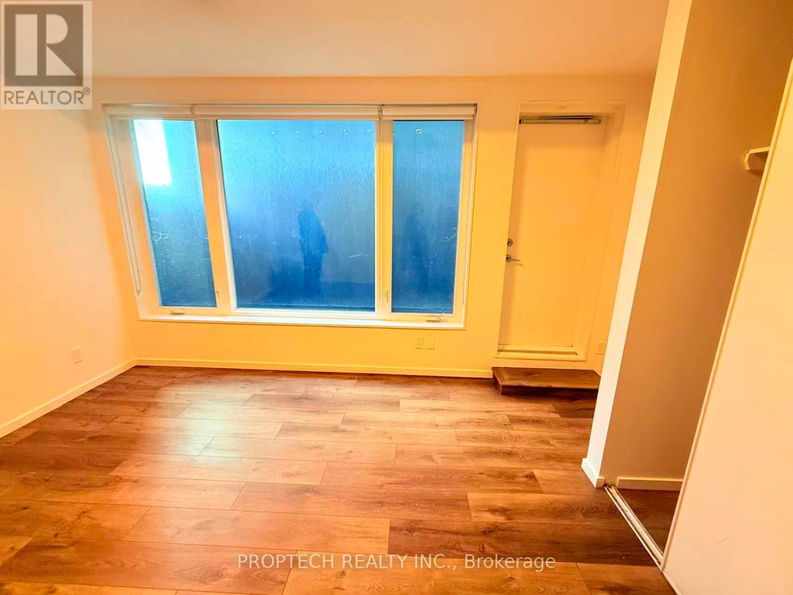 A room with a window and wooden flooring.