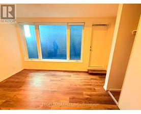 A room with a window and wooden flooring.