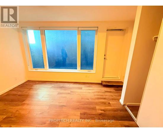 A room with a window and wooden flooring.