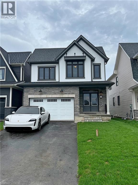 A white car is parked in front of a two-story house.