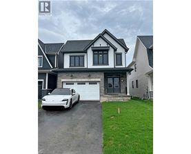 A white car is parked in front of a two-story house.