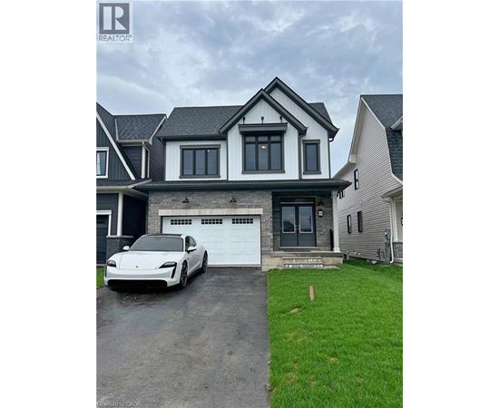 A white car is parked in front of a two-story house.