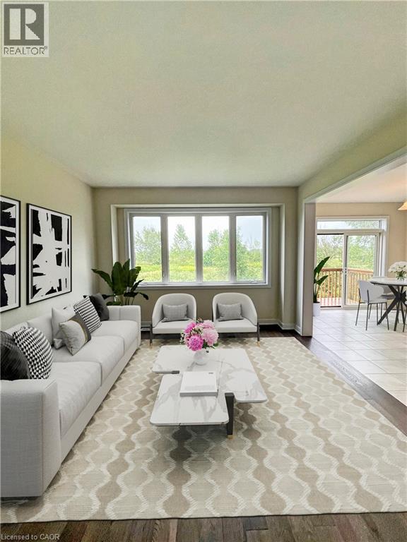 A living room with a white couch and a coffee table with a vase of flowers on it.