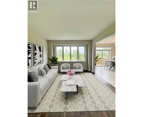 A living room with a white couch and a coffee table with a vase of flowers on it.