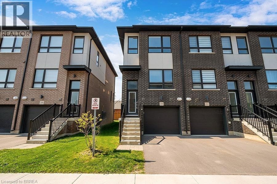 Two modern brick apartment buildings with garages and a no parking sign in front.
