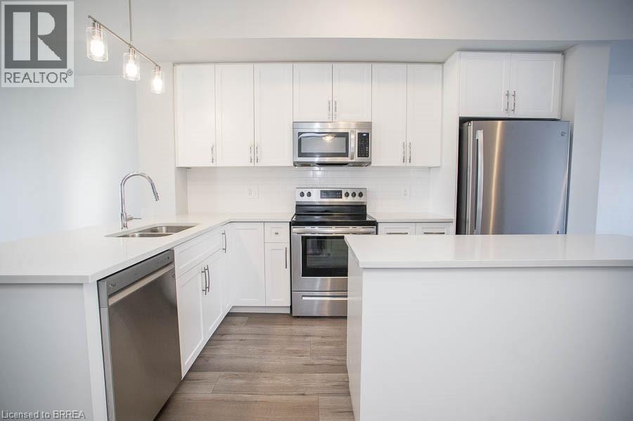 A modern kitchen with white cabinets and stainless steel appliances.