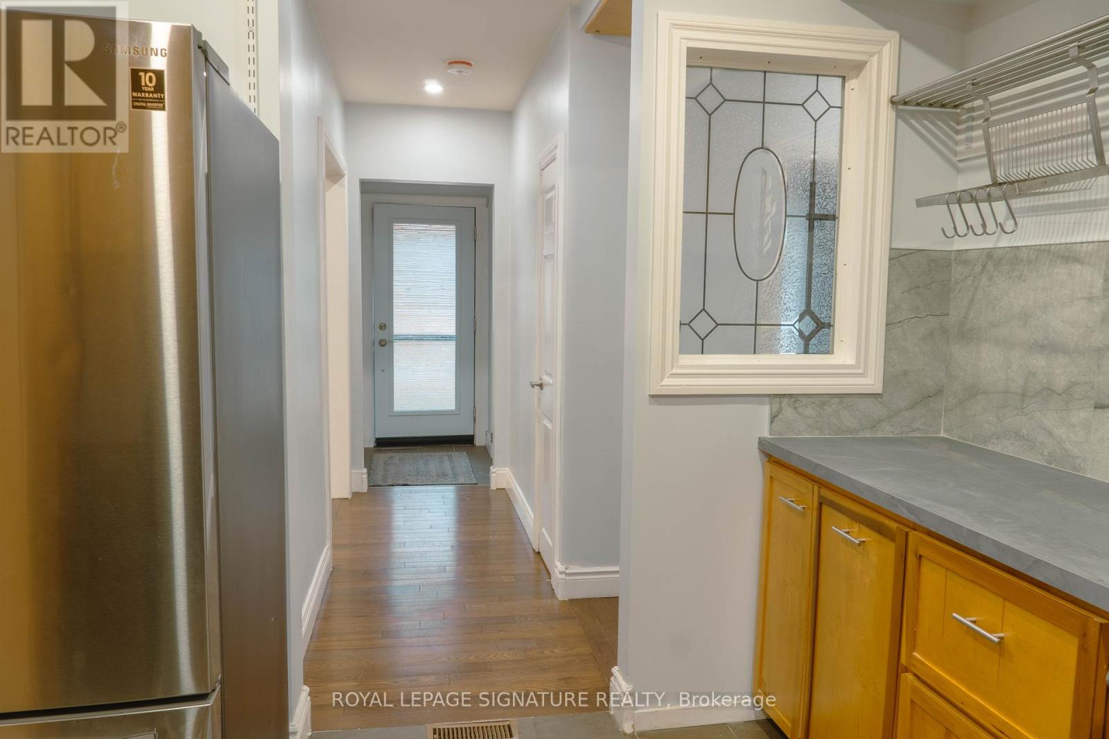 A kitchen with a refrigerator and wooden cabinets.