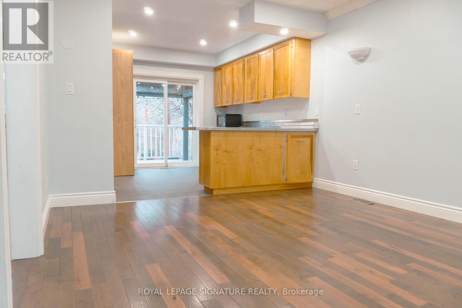 A kitchen with wooden floors and cabinets.