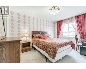 A bedroom with a bed, nightstand, and chair.