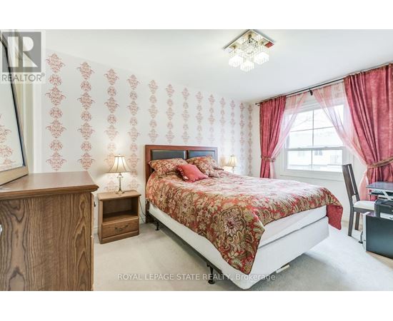 A bedroom with a bed, nightstand, and chair.