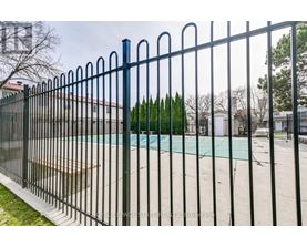 A black metal fence surrounds a pool.