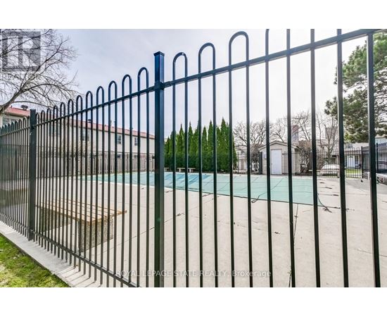 A black metal fence surrounds a pool.