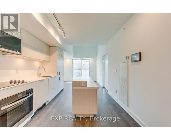 A kitchen with white cabinets and a wooden island.