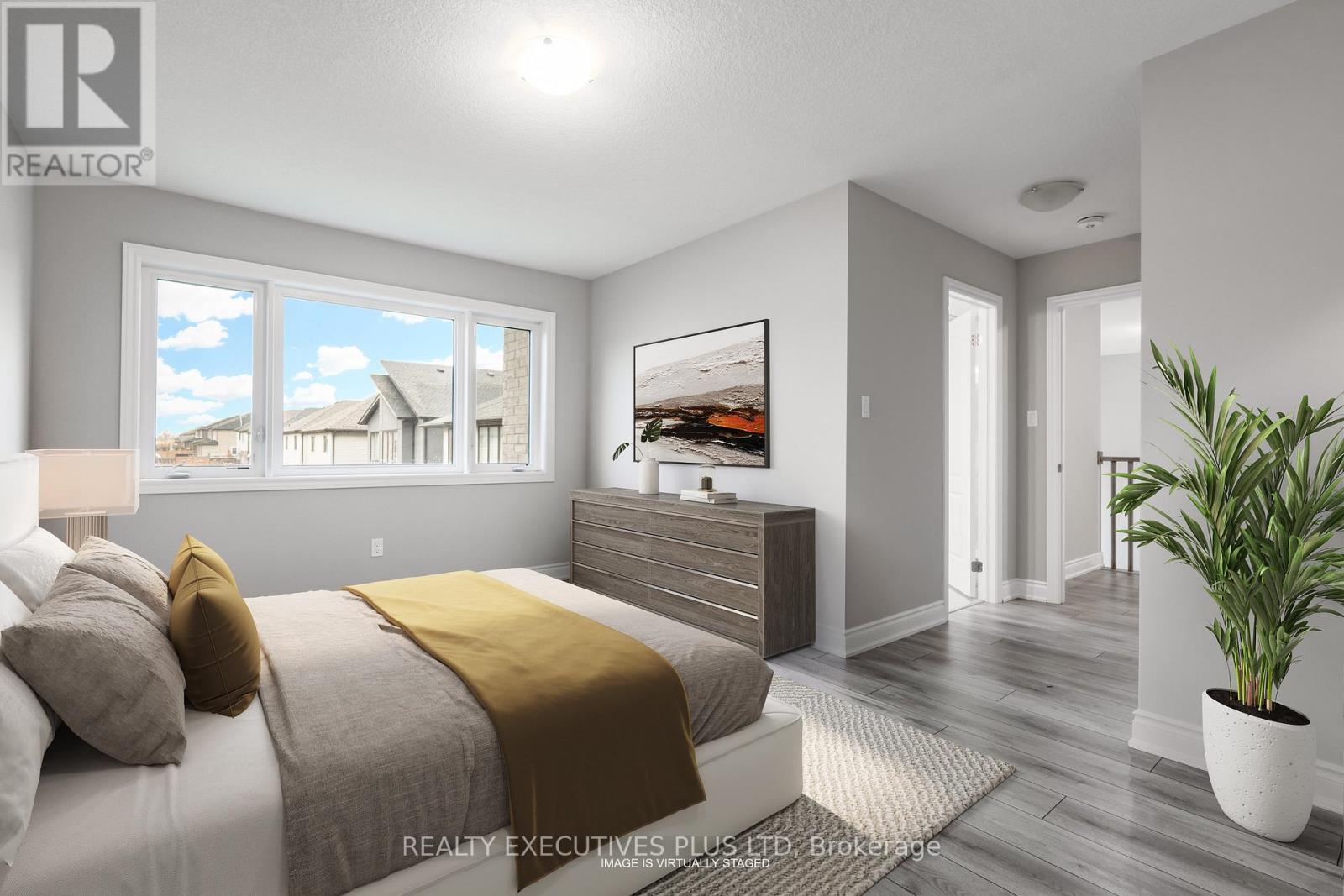 A bedroom with a bed, dresser, and a window overlooking a residential area.