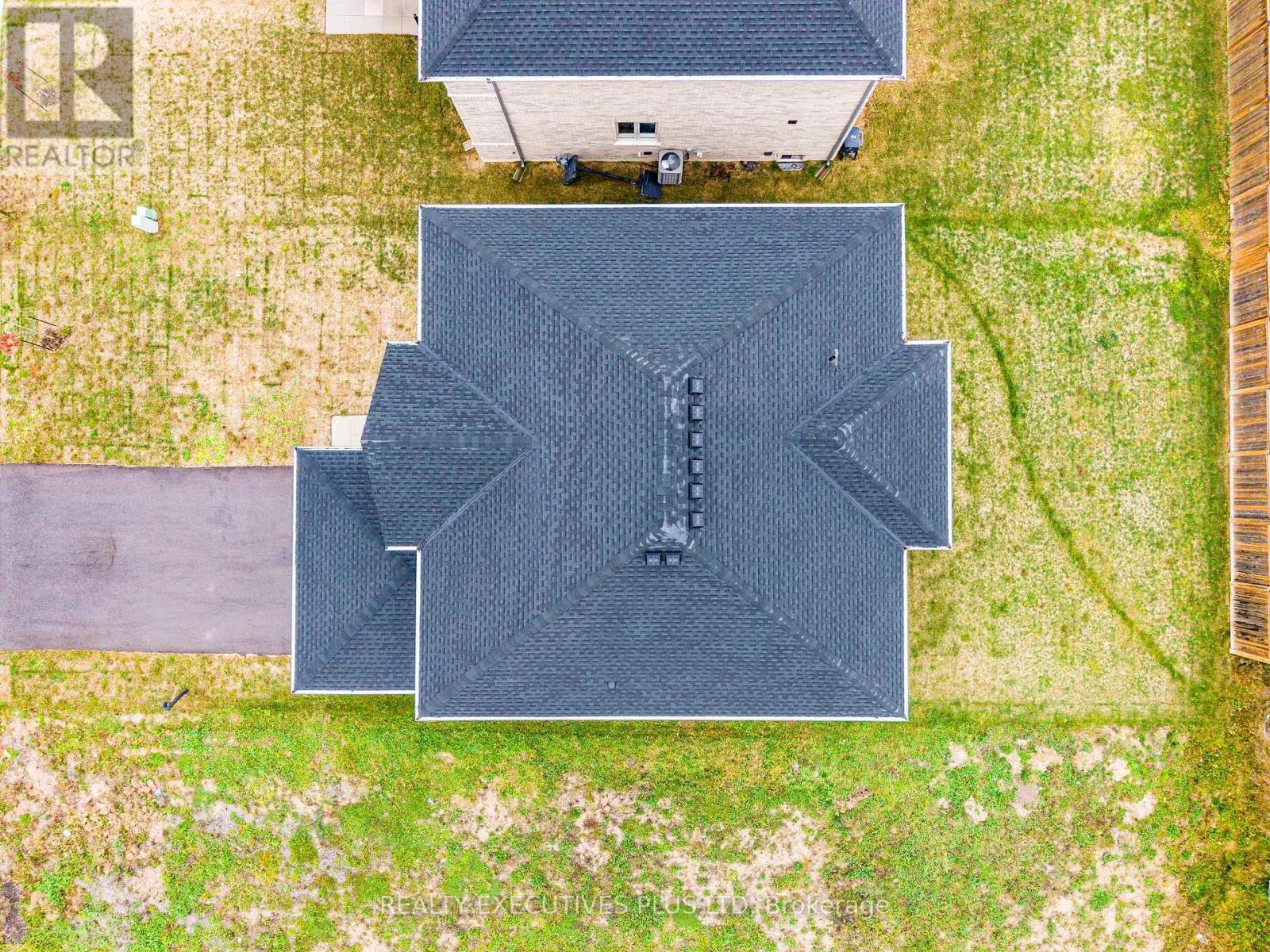 A large black rectangular object with a pattern on it is in the center of a grassy area.