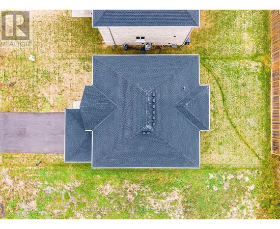 A large black rectangular object with a pattern on it is in the center of a grassy area.