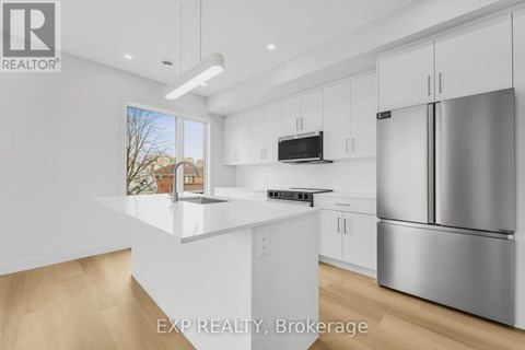 A modern kitchen with white cabinets and stainless steel appliances.