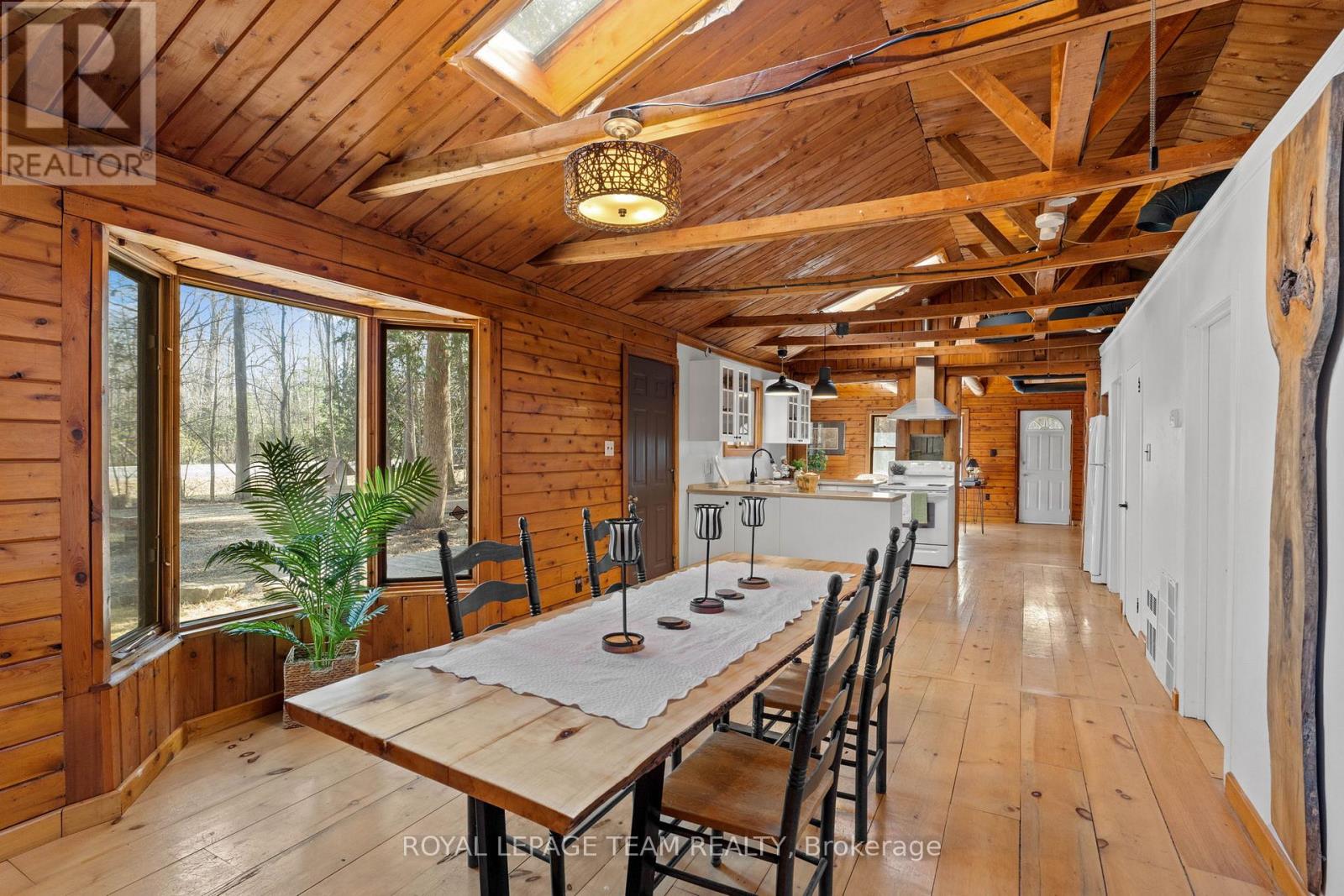 A wooden dining room with a table set for six.