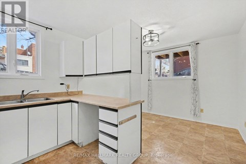 A kitchen with white cabinets and a wooden countertop.