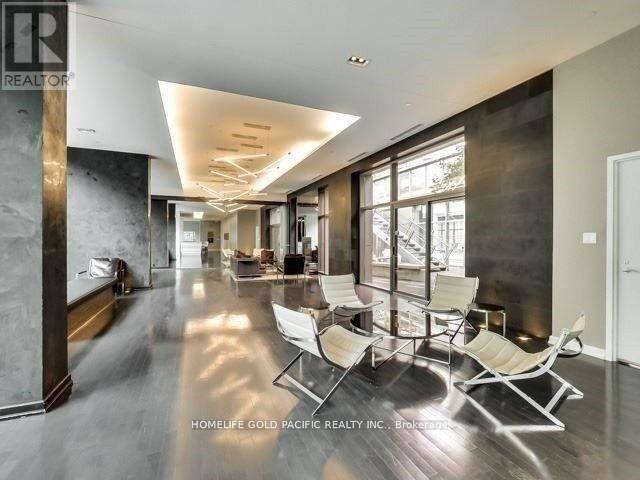 A spacious living room with a long row of chairs facing a large window.