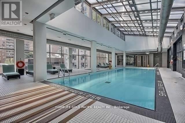 A swimming pool inside a building with a tiled floor.