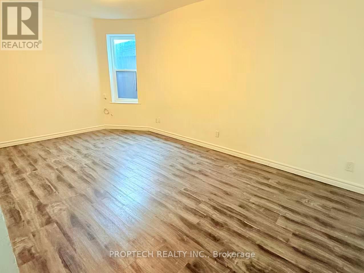 A room with wooden flooring and a window.
