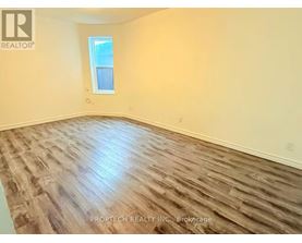 A room with wooden flooring and a window.