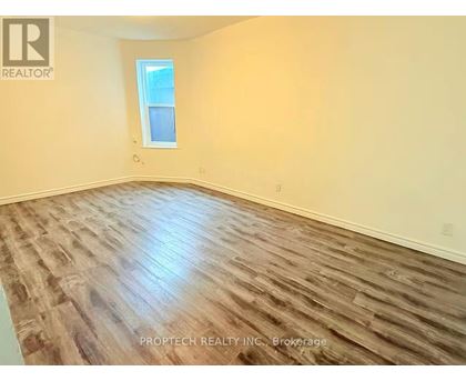 A room with wooden flooring and a window.