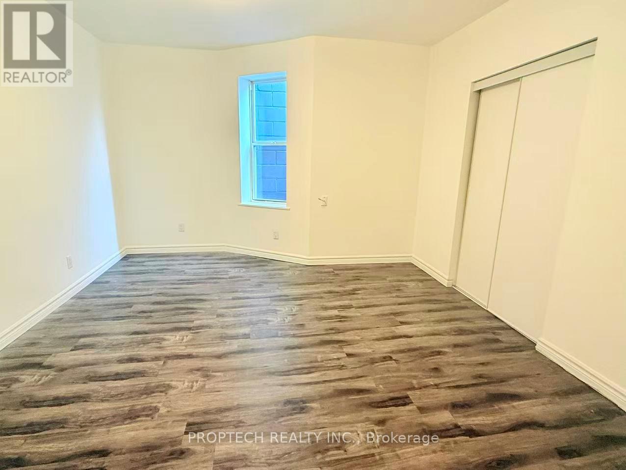 A room with wooden flooring and a window.