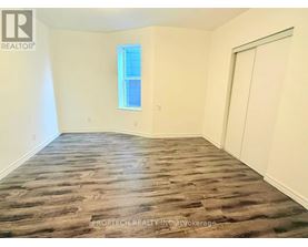 A room with wooden flooring and a window.