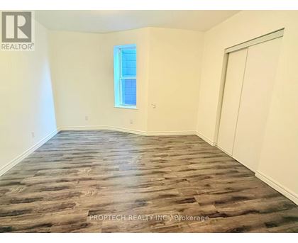 A room with wooden flooring and a window.