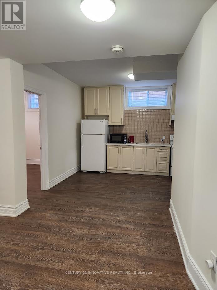A kitchen area with wooden floors and white appliances.