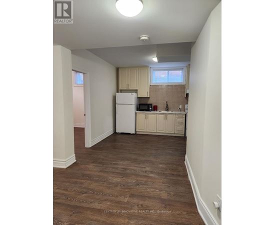 A kitchen area with wooden floors and white appliances.