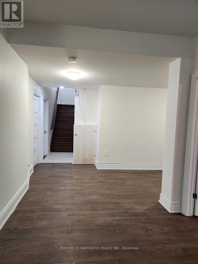 A hallway with wood floors and white walls.