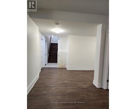 A hallway with wood floors and white walls.
