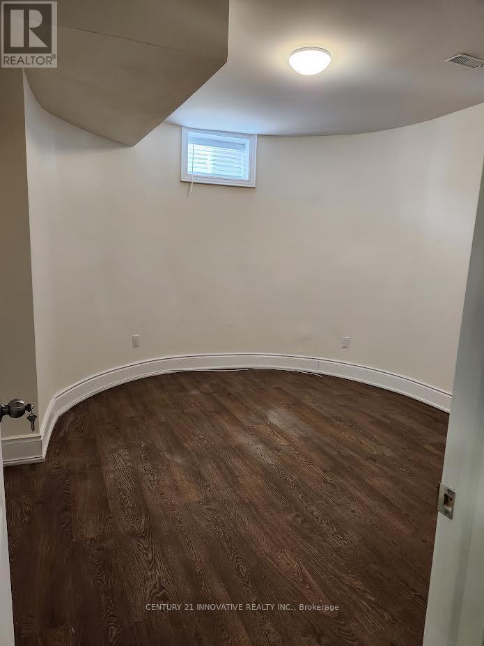 A room with wooden flooring and a window with blinds.