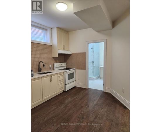 A kitchen with wooden floors and white appliances.