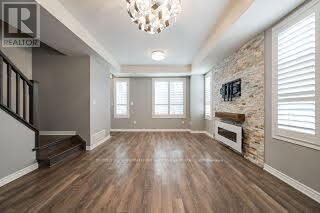 A spacious room with wooden floors and a stone wall.