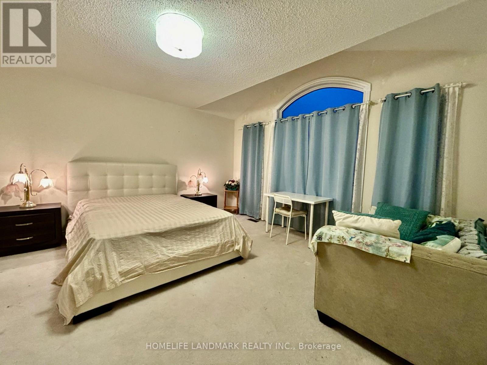 A bedroom with a large bed and a smaller bed in the corner.