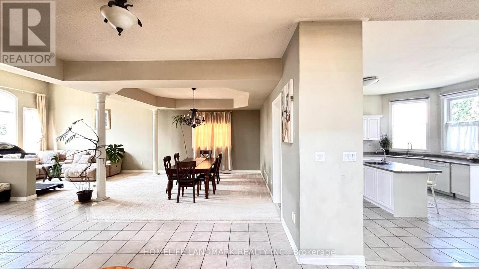 A well-lit, spacious kitchen and dining area with a large island and a dining table with chairs.