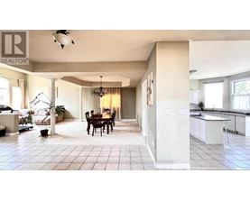 A well-lit, spacious kitchen and dining area with a large island and a dining table with chairs.