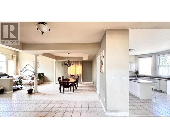 A well-lit, spacious kitchen and dining area with a large island and a dining table with chairs.