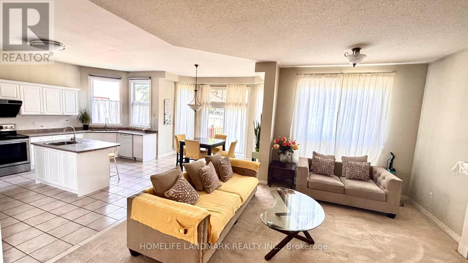 A living room with a yellow couch and a glass coffee table.