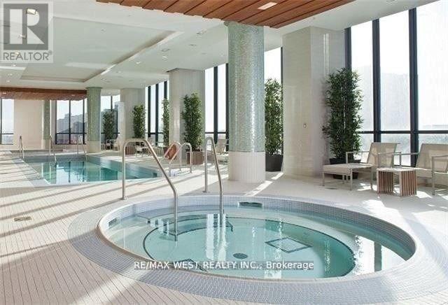 A large indoor swimming pool with a hot tub in the middle.