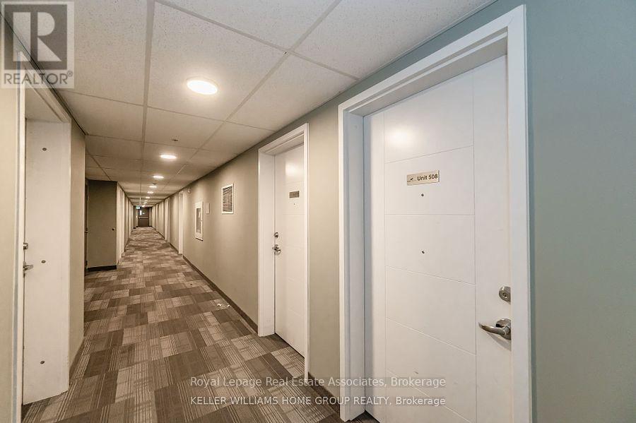 A long hallway with doors on both sides and a carpeted floor.