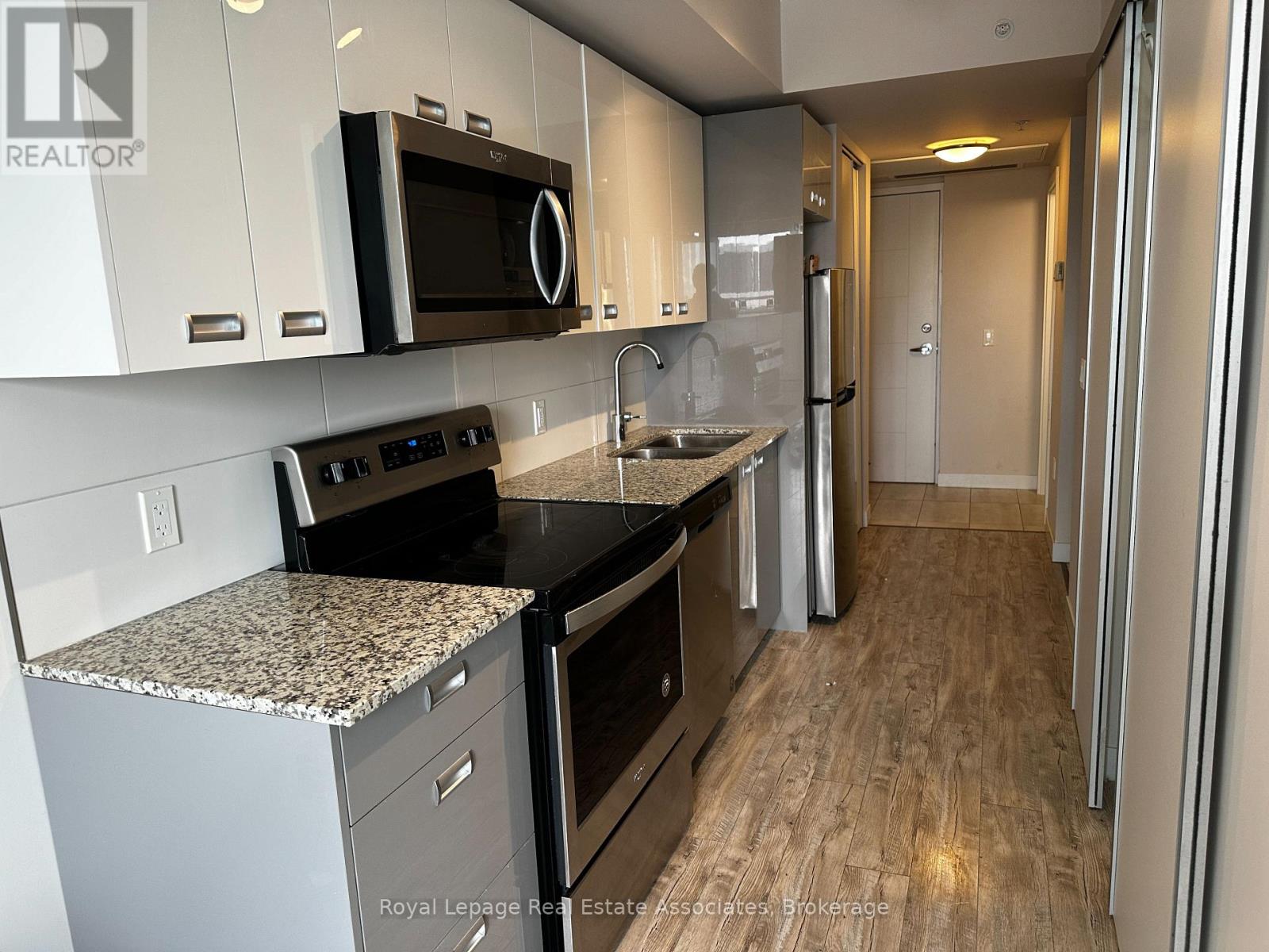 A kitchen with a granite countertop and stainless steel appliances.