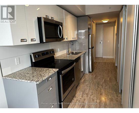 A kitchen with a granite countertop and stainless steel appliances.