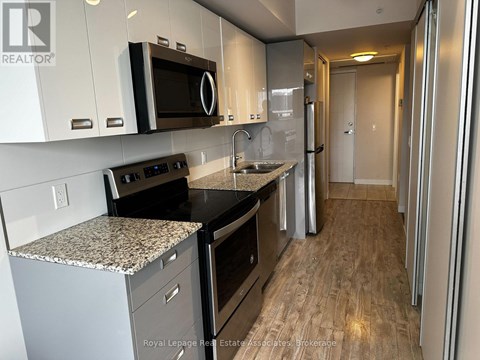 A kitchen with a granite countertop and stainless steel appliances.